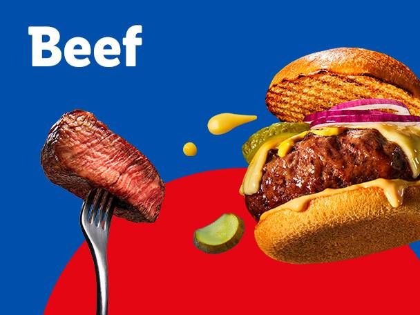 A beef steak on a fork and a beef burger with cheese, pickles, and onions.