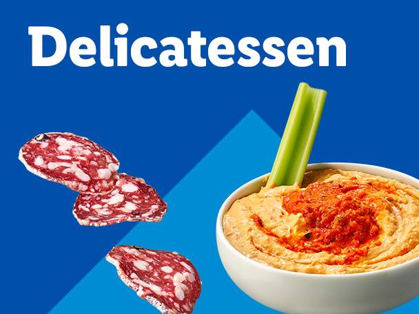 Salami slices and a bowl of hummus with a celery stick on a blue background.