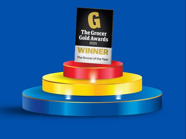A tiered podium with a black and white award plaque for 'The Grocer Gold Awards 2025 Winner'.
