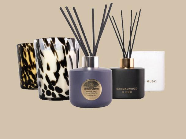A selection of scented candles and reed diffusers in stylish glass and ceramic jars.