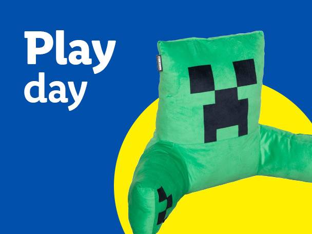 Green pixelated character backrest pillow on a blue and yellow background with text 'Play day'.