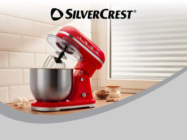 Red retro stand mixer with a stainless steel bowl on a kitchen counter.
