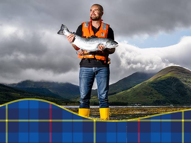 Man holding salmon, tartan background.