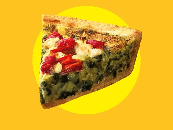 Slice of quiche with spinach, feta, and red peppers on a yellow background.